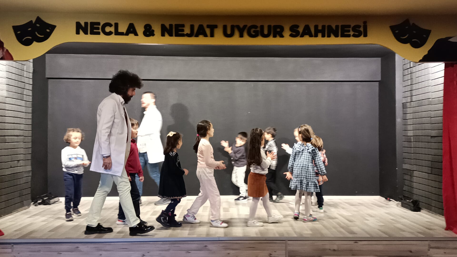 Eğitmen ve öğrenciler sahnede birlikte çalışırken