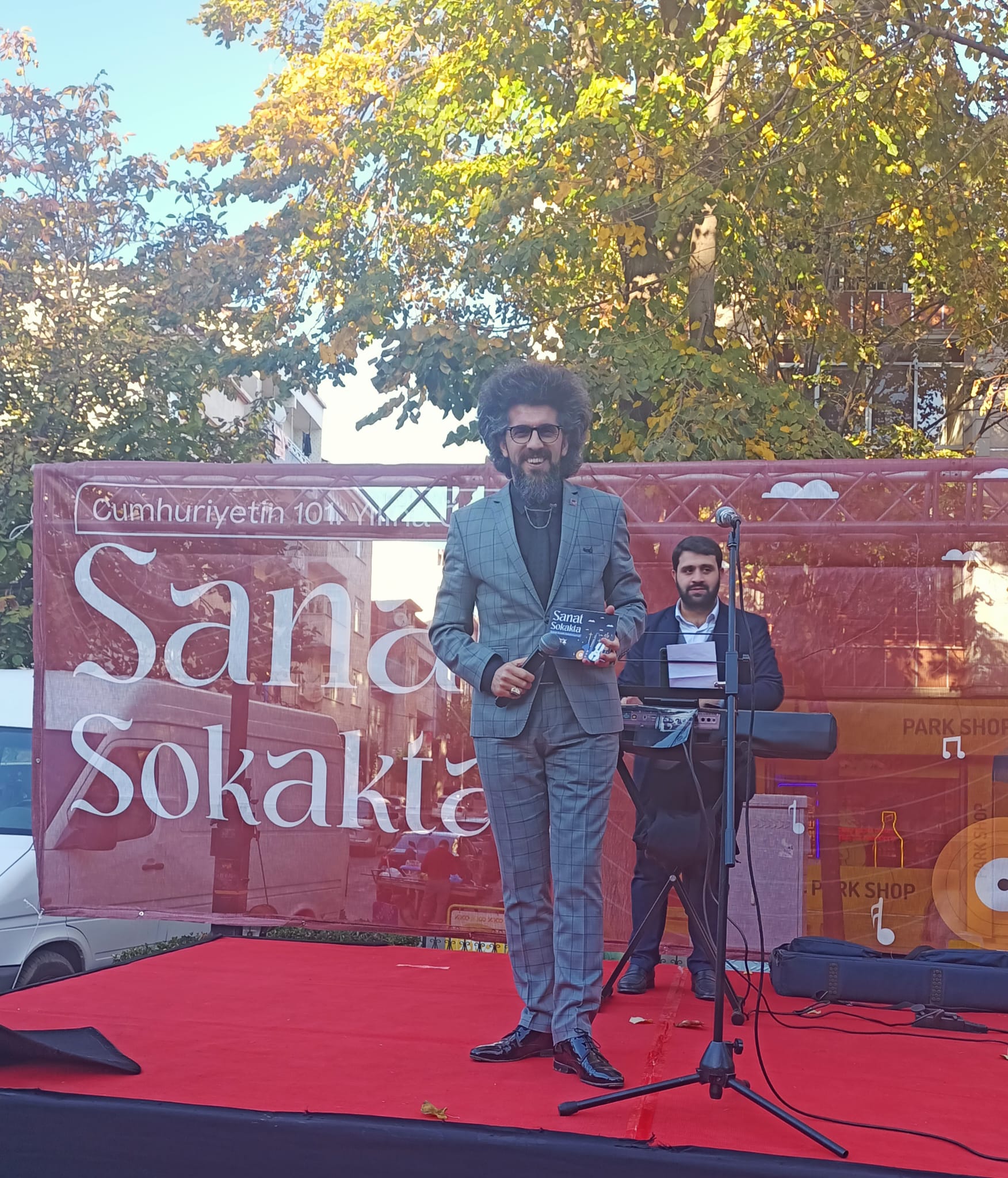 İlyas Çağlayan açık havadaki bir etkinlikte sunuculuk yaparken